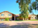 Exterior view of a charming home featuring unique Tudor-style architecture and a well-kept lawn at 19322 E Calle De Flores --, Queen Creek, AZ 85142