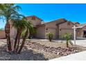 Charming single-story home featuring a two-car garage, desert landscaping with palms, and a well-maintained front yard at 12941 W Flower St, Avondale, AZ 85392