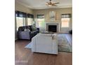 Cozy living room with fireplace, ceiling fan, and large windows, creating a warm and inviting atmosphere at 15055 S 40Th Pl, Phoenix, AZ 85044