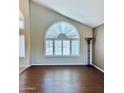 Bright living area featuring a large arched window, shutters, and hardwood floors, perfect for entertaining guests at 15055 S 40Th Pl, Phoenix, AZ 85044