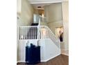 Elegant staircase with white railings, complemented by a stylish black accent table and decorative niche at 15055 S 40Th Pl, Phoenix, AZ 85044
