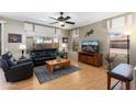 Comfortable living room with a ceiling fan, a large window, and a black leather furniture set at 16160 W Starlight Dr, Surprise, AZ 85374