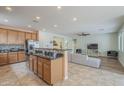 Open kitchen with island, breakfast bar, stainless appliances, and seamless flow into the living area at 16526 W Calle Lejos --, Surprise, AZ 85387