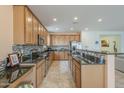 Bright kitchen featuring granite counters, stainless steel appliances, mosaic backsplash, and tiled floors at 16526 W Calle Lejos --, Surprise, AZ 85387