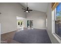 Bright living room with vaulted ceiling, tile flooring, neutral colors, and sliding glass door to backyard at 1683 W Maplewood St, Chandler, AZ 85286