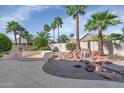 An expansive backyard features professional landscaping, palm trees, and a peaceful waterfall feature at 17806 N Becke Ln, Surprise, AZ 85374