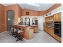 Open kitchen featuring a breakfast bar, ample counter space, tile flooring, and stainless steel appliances at 17806 N Becke Ln, Surprise, AZ 85374