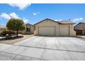 Inviting single-story home with a three-car garage, mature trees, and a concrete driveway at 18237 W Port Au Prince Ln, Surprise, AZ 85388