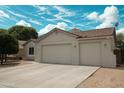 Single-story home featuring a spacious two-car garage, desert landscaping, and a beautiful blue sky at 18237 W Port Au Prince Ln, Surprise, AZ 85388