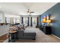 Comfortable living room with an entertainment center, neutral carpet, and ample natural light at 18237 W Port Au Prince Ln, Surprise, AZ 85388