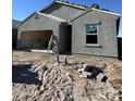 Exterior shot of a home under construction, showing unfinished landscaping and a partially completed garage at 2124 E Bucking Bronco Dr, San Tan Valley, AZ 85140