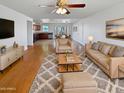 Spacious living room with hardwood floors, a ceiling fan, and modern neutral-toned furniture at 3702 E Karen Dr, Phoenix, AZ 85032