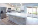 Updated kitchen with white cabinets, stainless steel appliances, island, and sliding doors to backyard at 4038 E Wescott Dr, Phoenix, AZ 85050