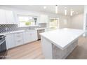 Modern kitchen featuring white cabinets, an island with stone accents, and stainless steel appliances at 4038 E Wescott Dr, Phoenix, AZ 85050
