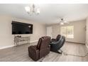 Comfortable living room featuring plush leather seating, neutral walls, and stylish ceiling fan at 43724 W Cowpath Rd, Maricopa, AZ 85138