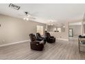 Comfortable living room featuring plush leather seating, neutral walls, and stylish ceiling fan at 43724 W Cowpath Rd, Maricopa, AZ 85138