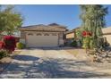 Well-maintained single-story home featuring desert landscaping, a tile roof, and a two-car garage at 4415 W Ellis St, Laveen, AZ 85339