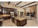 Gourmet kitchen features a large island, stone counters, and stainless steel appliances at 5641 E Grovers Ave, Scottsdale, AZ 85254