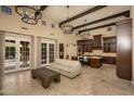 Spacious living room with travertine floors, beamed ceilings and French doors at 5641 E Grovers Ave, Scottsdale, AZ 85254