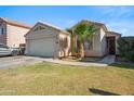Single-Gathering home featuring a large garage, desert landscaping, and a charming palm tree at 7329 W Lamar Rd, Glendale, AZ 85303