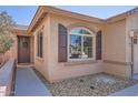 Close-up of the front exterior showcasing the front door with decorative wreath, window shutters and stone accents at 7589 W Quail Track Dr, Peoria, AZ 85383