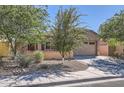 Front exterior with desert landscaping, mature trees, and a two-car garage at 7589 W Quail Track Dr, Peoria, AZ 85383