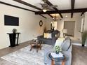 This bright living room features beamed ceilings, a ceiling fan, and opens to the dining area at 7843 E Valley View Rd, Scottsdale, AZ 85250