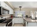 Bright kitchen featuring stainless steel appliances, white cabinets, and a breakfast bar at 804 W Bentrup St, Chandler, AZ 85225