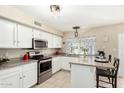 Bright kitchen featuring stainless steel appliances, white cabinets, and a breakfast bar at 804 W Bentrup St, Chandler, AZ 85225