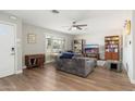 Comfortable living room with wood floors, ceiling fan, and plantation shutters at 8656 E Plaza Ave, Scottsdale, AZ 85250