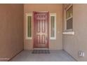 Inviting covered front porch with a wood front door, two side windows and desert paint at 19011 E Carriage Way, Queen Creek, AZ 85142