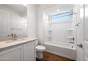 A well-lit bathroom has a shower/tub combination, a vanity with stone countertops, and wood look tile floors at 21277 N 272Nd Ave, Buckeye, AZ 85396