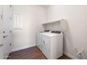 Modern laundry room featuring white washer and dryer, shelf, and light wood-look flooring at 21277 N 272Nd Ave, Buckeye, AZ 85396