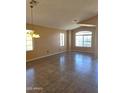 Neutral living room featuring large windows and tile flooring at 11363 W Locust Ln, Avondale, AZ 85323