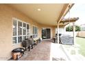 Spacious covered patio with brick flooring, multiple seating areas, and access to the backyard at , Gilbert, AZ 85233