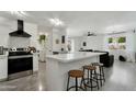 Modern kitchen with white cabinets, a breakfast bar, and stainless steel appliances at 10428 S 43Rd St, Phoenix, AZ 85044