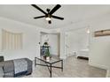 Open-concept living room with light gray wood floors, a ceiling fan, and neutral decor at 10428 S 43Rd St, Phoenix, AZ 85044