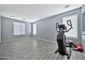 Spacious exercise room with gray wood-look floors, neutral paint, and large windows providing ample natural light at 10775 W Davis Ln, Avondale, AZ 85323