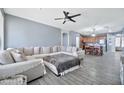 Open-concept living area features a large sectional sofa, ceiling fan, and views into the adjacent kitchen at 10775 W Davis Ln, Avondale, AZ 85323