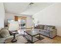 Neutral living room featuring tile flooring, couches and backyard access via sliding door at 153 W Hillside St, Mesa, AZ 85201