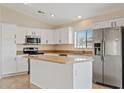 Bright kitchen featuring stainless steel appliances, white cabinets, and central island at 16585 W Tonto St, Goodyear, AZ 85338