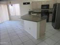 Bright kitchen with an island featuring granite counters, neutral cabinetry, and stainless steel appliances at 1912 E Doral Dr, Chandler, AZ 85249