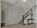 Contemporary staircase with brick accent wall, black metal railings, and light carpet on the stairs at 2522 E Presidio St, Mesa, AZ 85213