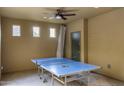 Well-lit bonus room with ceiling fan and a full-size ping pong table at 3911 E Rockingham Rd, Phoenix, AZ 85050