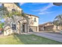 Lovely two-story home showcasing a stucco exterior, arched entry, and lush green lawn at 40613 N Jerlyn Pl, San Tan Valley, AZ 85140