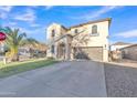 Inviting two-story home with a stucco exterior, arched doorway, and long driveway at 40613 N Jerlyn Pl, San Tan Valley, AZ 85140
