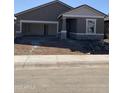 New home with stone accents, neutral paint, no landscaping, and a two-car garage with the door open at 4131 E Kolin Ln, San Tan Valley, AZ 85143