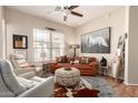Cozy living room boasts stylish decor with a ceiling fan, leather couch, and unique ottoman at 42424 N Gavilan Peak Pkwy # 63212, Anthem, AZ 85086