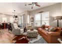 Bright living room with a ceiling fan, hardwood floors, and a comfortable leather couch at 42424 N Gavilan Peak Pkwy # 63212, Anthem, AZ 85086