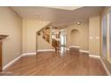 Spacious living room showcasing hardwood floors, a fireplace, arched doorway, staircase, and neutral paint at 4927 E Hazel Dr # 2, Phoenix, AZ 85044